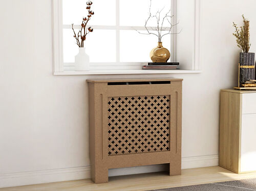Wooden radiator cover with a decorative front panel placed under a window with home decorations. Click to see the products in the collection.
