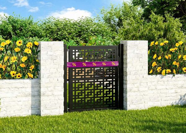 Decorative metal garden gate set between two stone pillars, with tall yellow flowers on each side. 