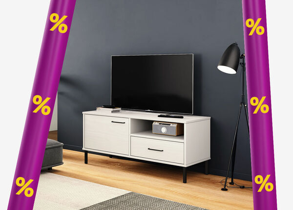 White TV cabinet with TV on top, next to a dark grey sofa and a black floor lamp, in a styled living room framed by purple promotional bands with yellow discount icons.