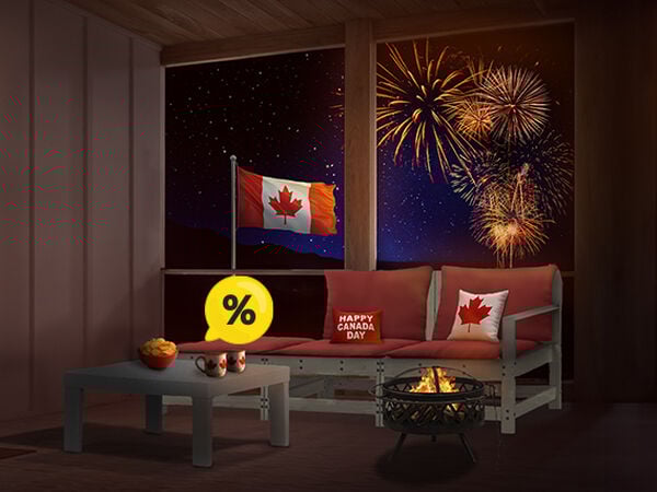 Wooden sofa with red cushions, Canada Day pillows, coffee table, and fire pit on a styled patio with Canadian flag and fireworks at night. Yellow discount symbol. Click to see the products in the offer.