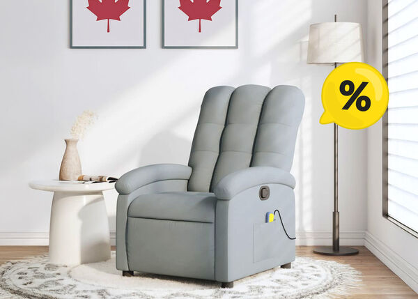 Gray massage recliner armchair with yellow percentage icon, next to side table and floor lamp, with two framed Canadian flag pictures on the wall in a styled living room.