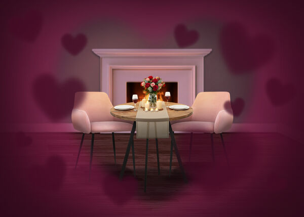 Romantic dining setup with a small round table set for two, pink upholstered chairs, candles and a bouquet of roses, placed in front of a lit fireplace, with soft heart-shaped overlays creating a Valentine&rsquo;s Day atmosphere.