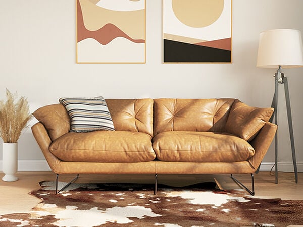 Light brown leather sofa, floor lamp and textured rug in a styled living room. Click to see the products in the collection.