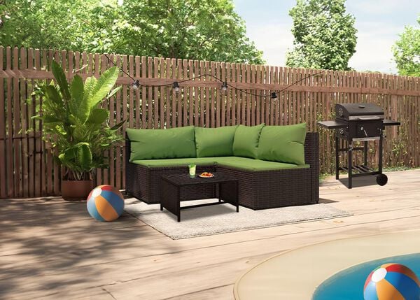 Sectional sofa with green cushions, coffee table, and BBQ grill by the pool in a styled backyard.