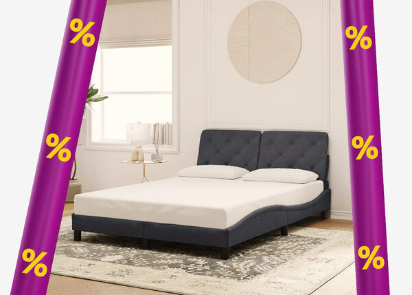 Dark grey upholstered bed frame with mattress and two pillows, a side table in a styled bedroom framed by purple promotional bands with yellow discount icons.