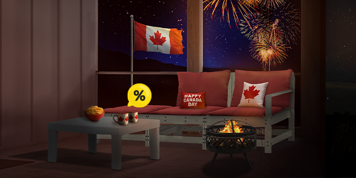 Wooden sofa with red cushions, Canada Day pillows, coffee table, and fire pit on a styled patio with Canadian flag and fireworks at night. Yellow discount symbol. Click to see the products in the offer.